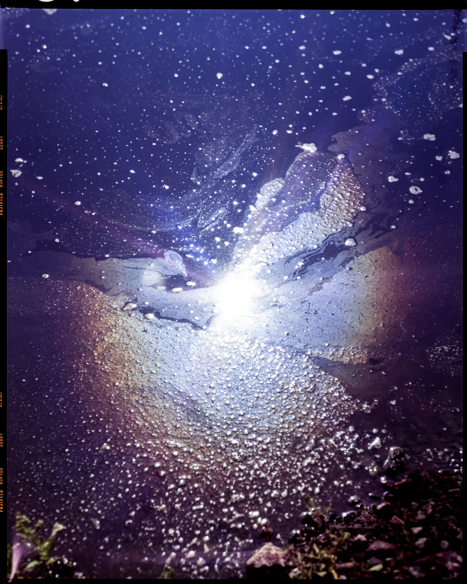 Reflejo lumínico sobre superficie húmeda y granulada